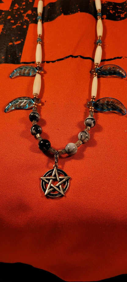 Collier d'os, de billes avec pentagramme de protection et plume de verre bleue