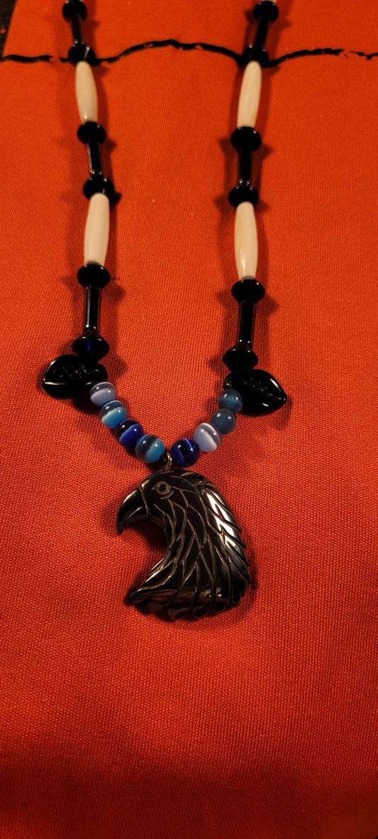 Necklace of bone, hematite and glass. Head of eagle in hematite stone