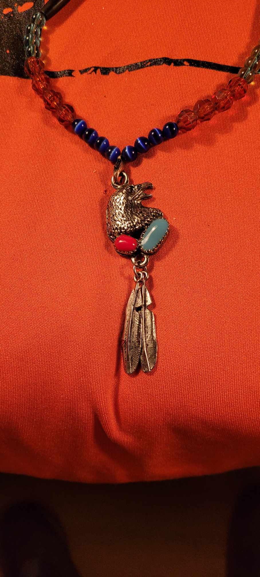 Black dyed bone necklace, blue and green colored glass beads with a silver eagle pendant with feathers.