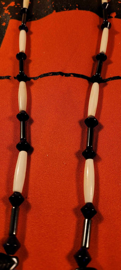 Necklace of bone, hematite and glass. Head of eagle in hematite stone