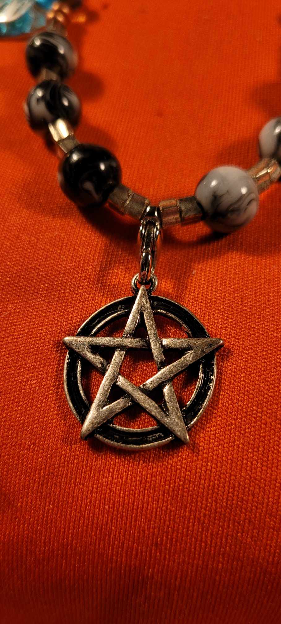 Necklace of bones, balls with pentagram of protection and blue glass feather