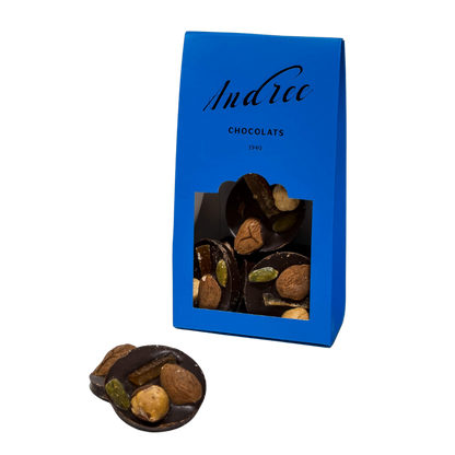 Les mendiants au chocolat de la marque Andrée Chocolats sont des disques de chocolat noir garnis de fruits secs et de noix, offrant une harmonie parfaite de saveurs sucrées et croquantes.